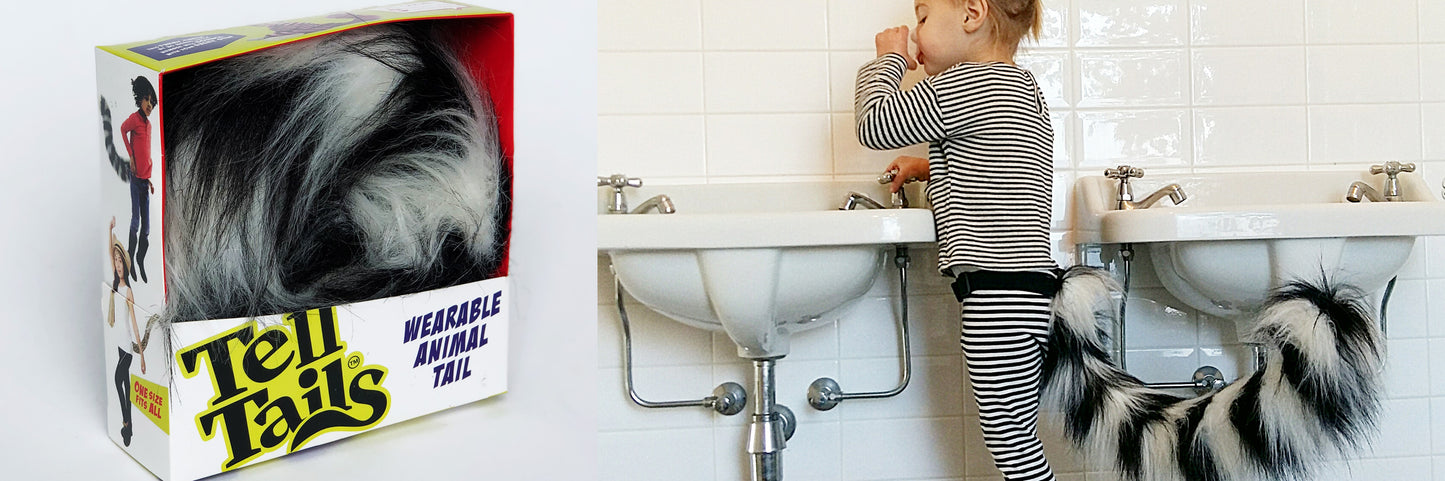 A Loopy Lemur tail by TellTails, featuring black and white stripes, sits next to a child in striped pajamas wearing a similar tail as a fun accessory at the bathroom sink. Ideal for cosplay or fancy dress, it adds charm to any adventure.