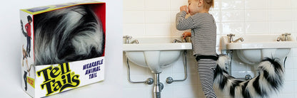 A Loopy Lemur tail by TellTails, featuring black and white stripes, sits next to a child in striped pajamas wearing a similar tail as a fun accessory at the bathroom sink. Ideal for cosplay or fancy dress, it adds charm to any adventure.